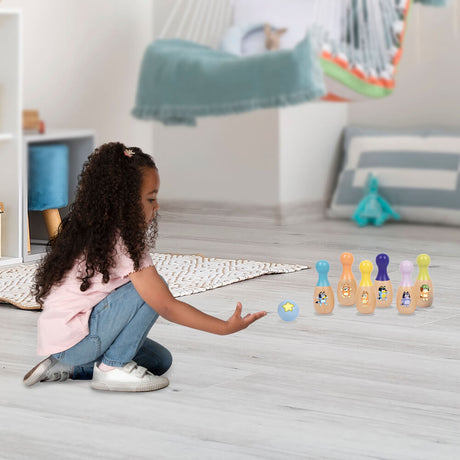 Child bowling with the Bluey Wooden Skittle Set on a rug